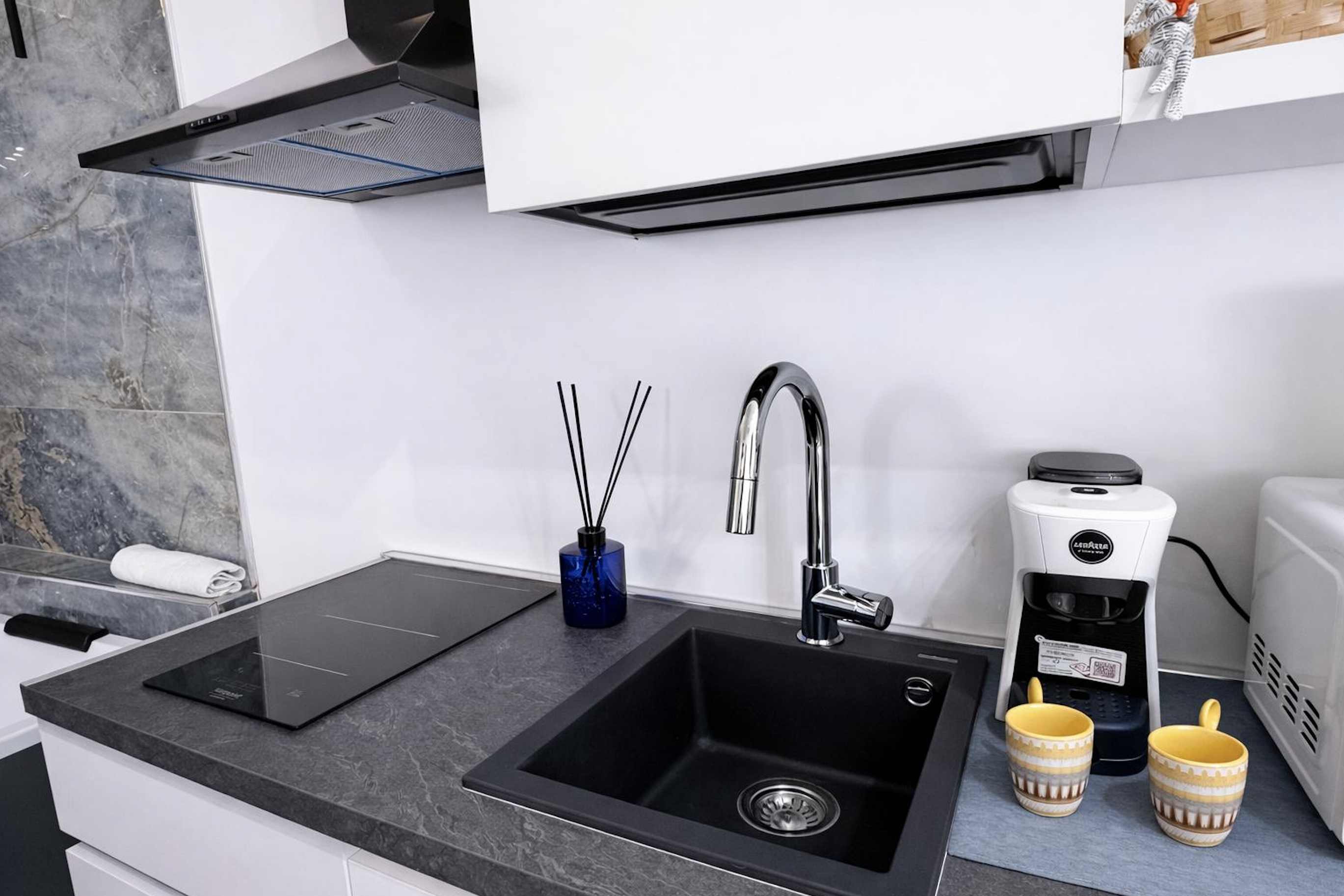 Kitchen with induction hob, black granite sink, and Lavazza coffee machine in Sunset Garden Mare, Porto Cesareo