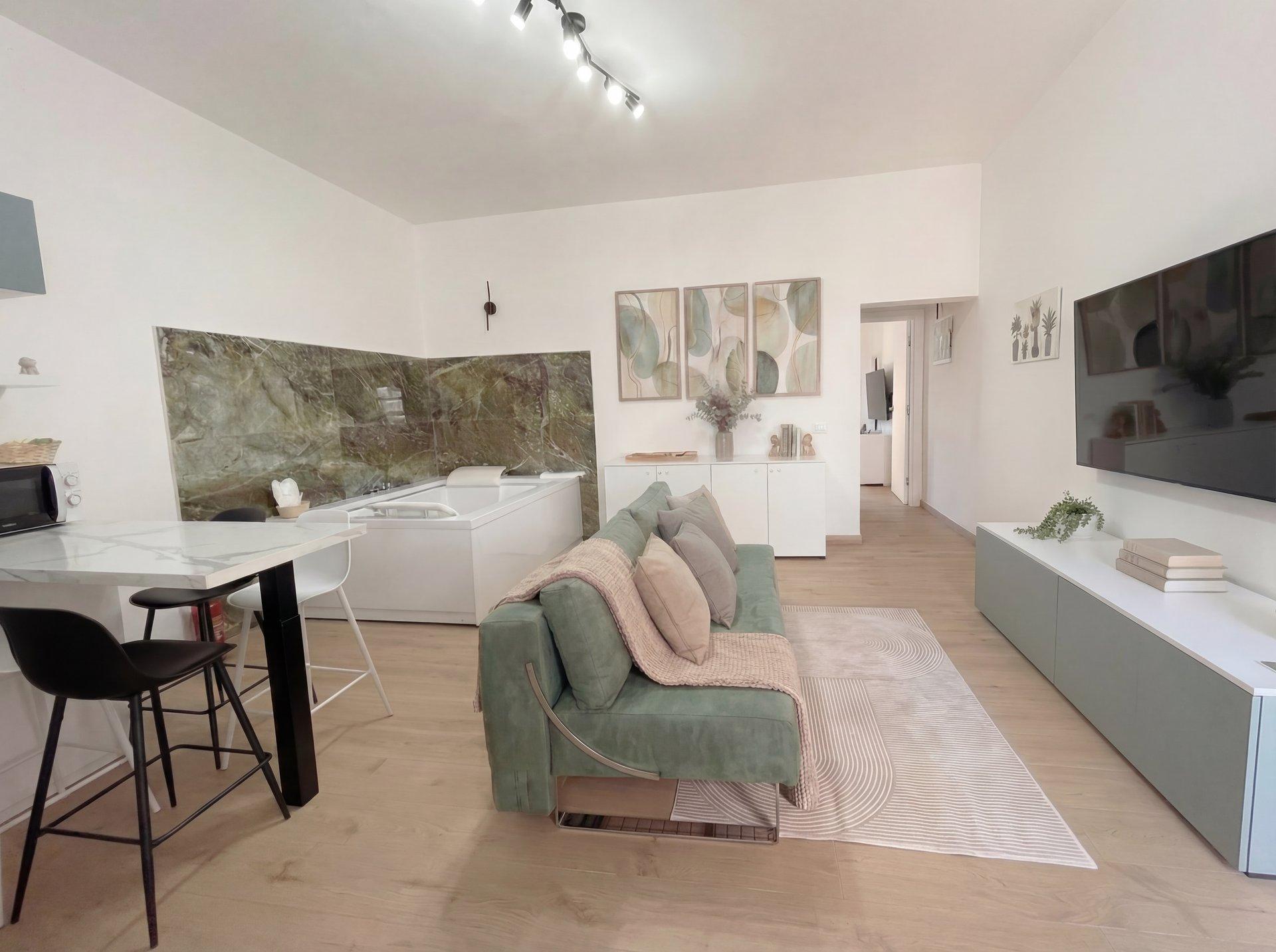 Open-plan living area with sofa, designer lighting, and warm interiors in Sunset Garden Terra apartment