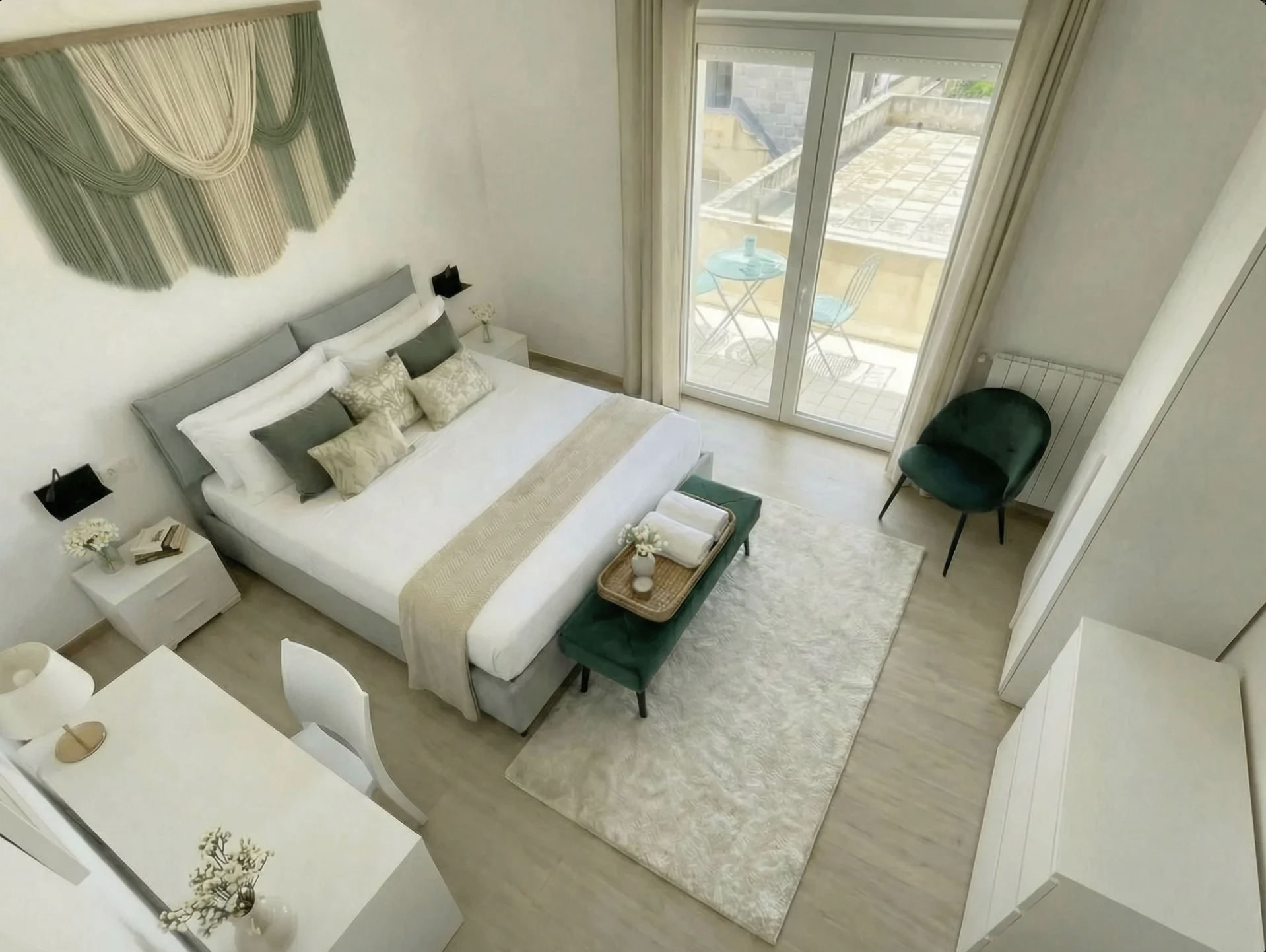 Aerial view of Terra bedroom showing queen bed, teal velvet bench, and balcony access