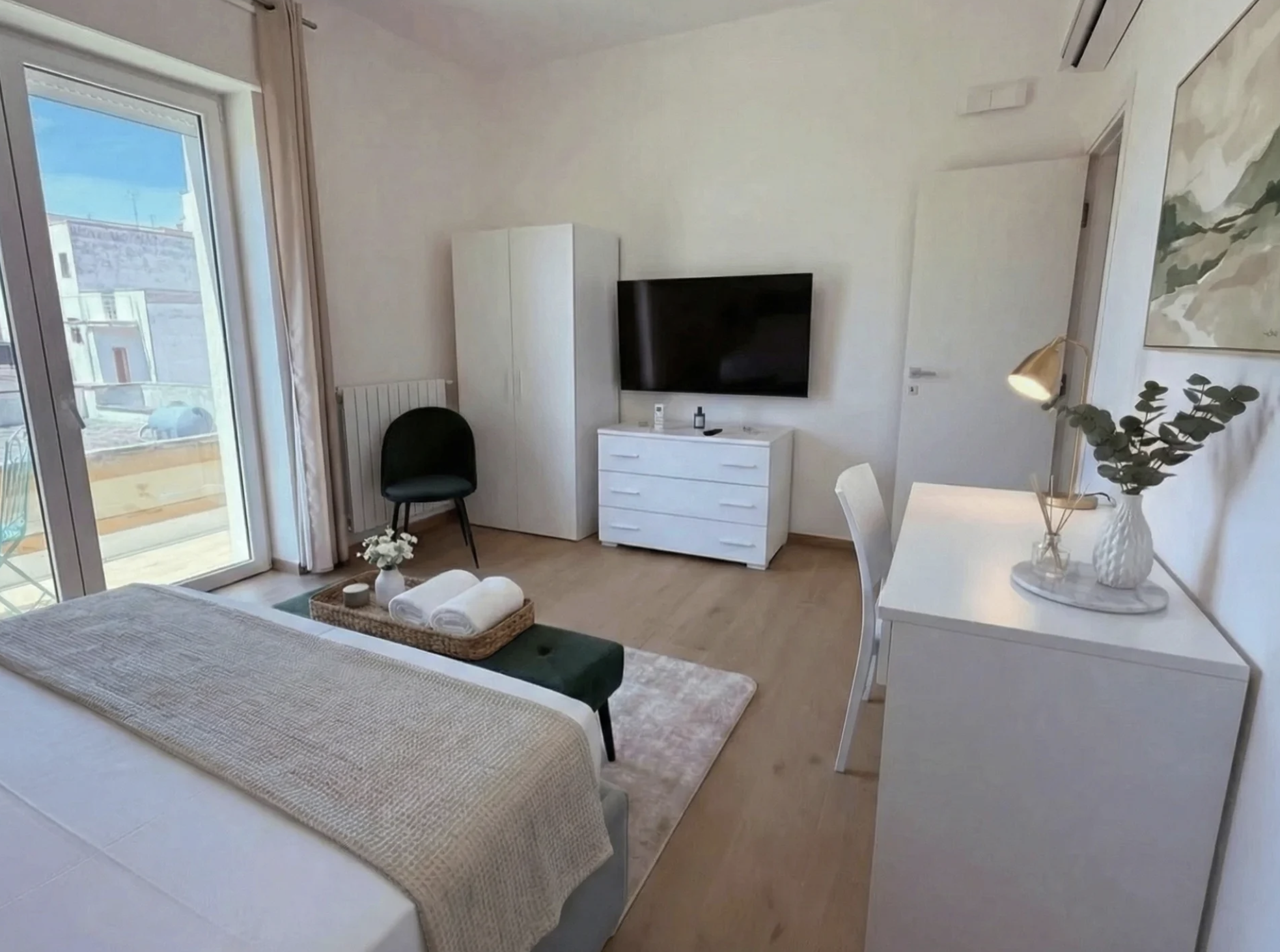 Terra bedroom with wall-mounted TV, wardrobe, and balcony view in Porto Cesareo